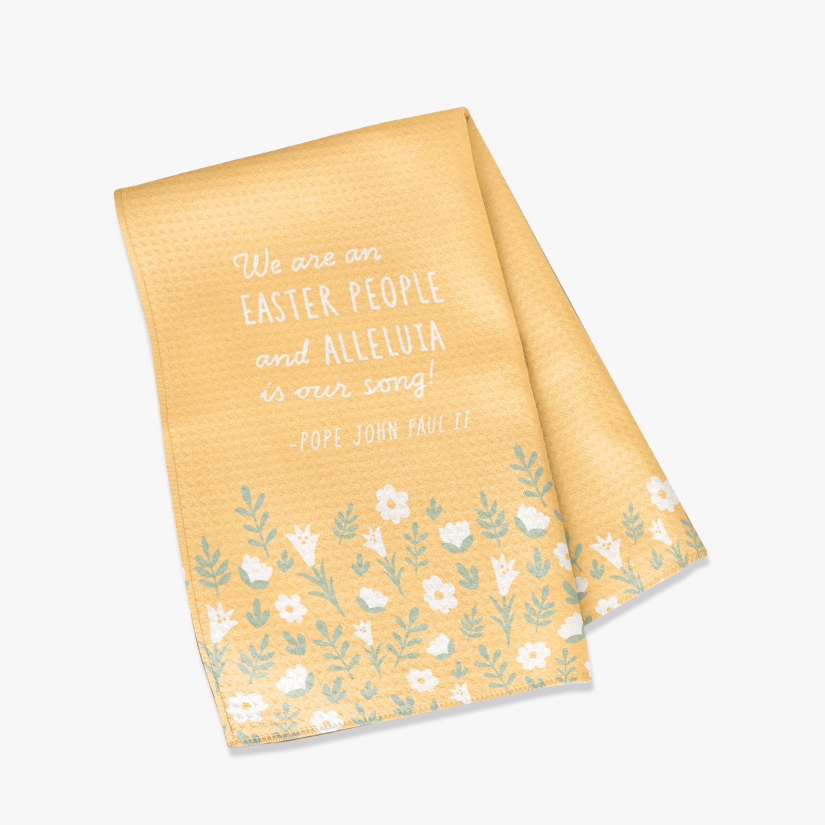 Yellow, waffle textured dish towel, folded in half, showing the design of subtle white flowers and pale green leaves with the wordings that say "We are an EASTER PEOPLE and ALLELUIA is our song! -Pope John Paul II"