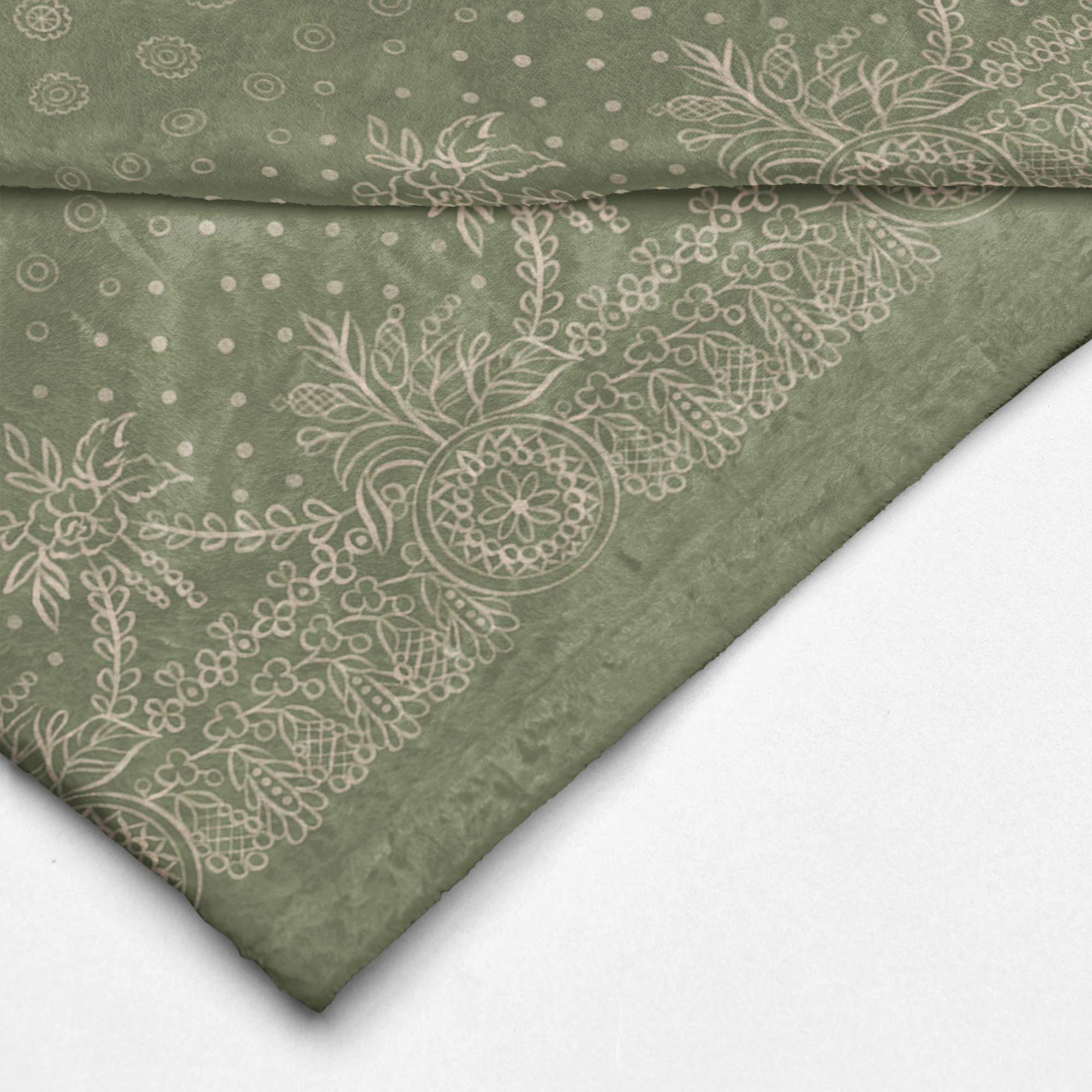 A green and white blanket with a white border, showcasing a gold design of craft symbols by Louis and Zélie.